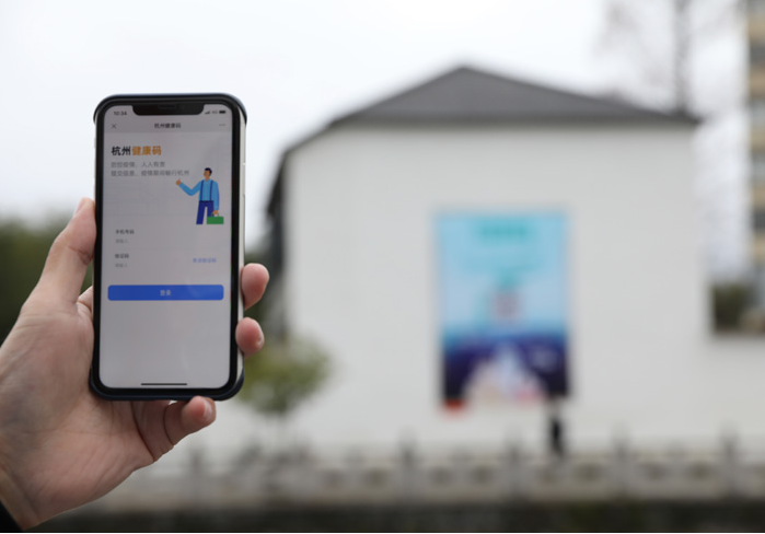 在浙江省杭州市臨安區(qū)天目山鎮(zhèn)，一名居民在“杭州健康碼”海報(bào)上掃碼申領(lǐng)個(gè)人二維碼。新華社發(fā)