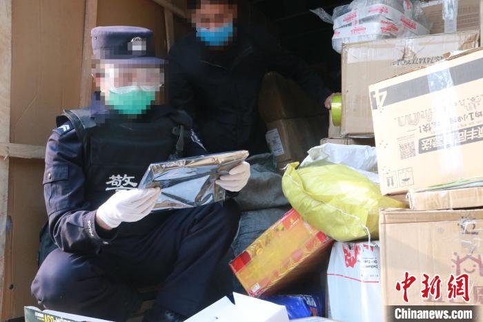 圖為勐康邊檢站民警在對(duì)快遞運(yùn)輸車輛進(jìn)行例行檢查?！钐?攝